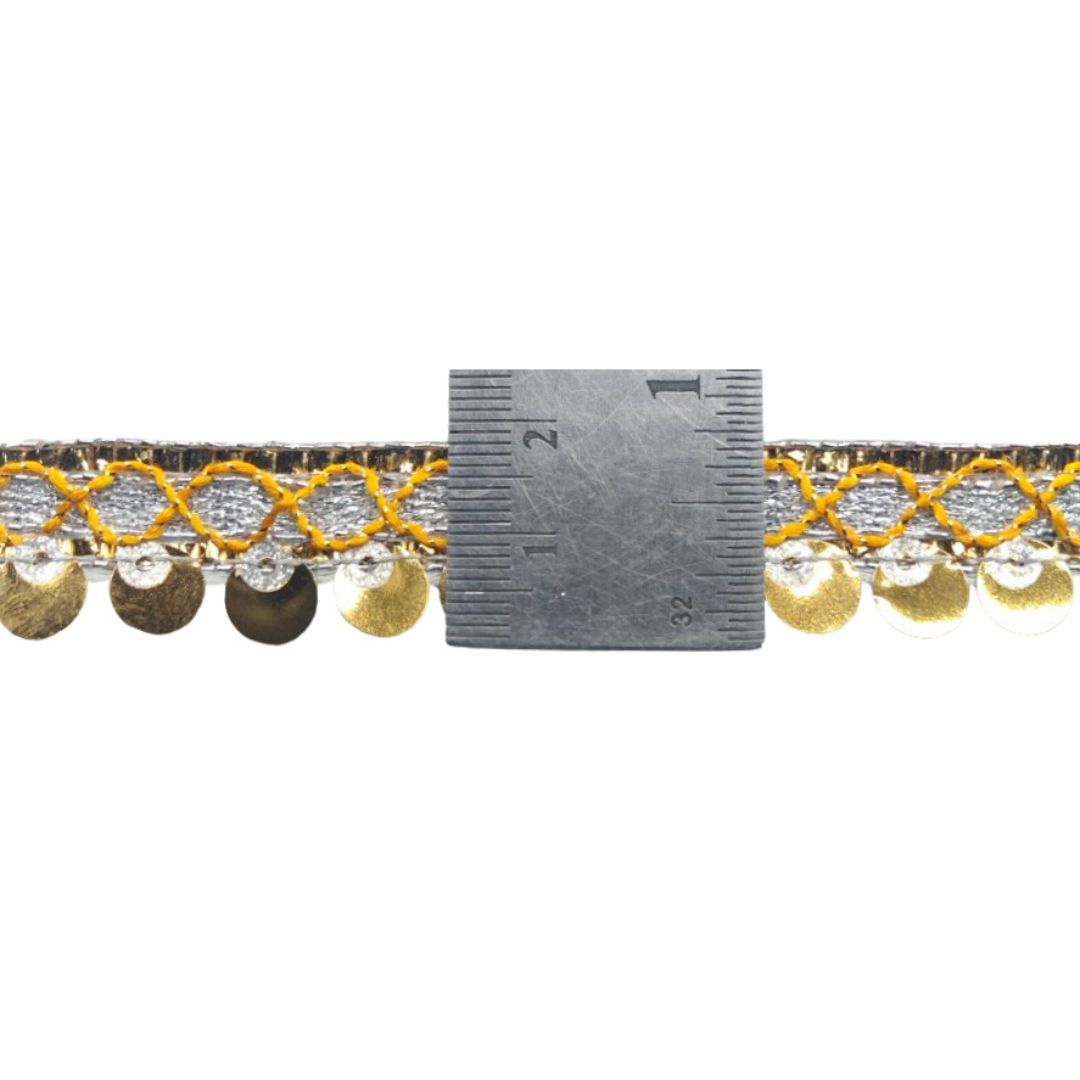 Decorative trim with yellow and gold patterns and a ruler for scale on a white background