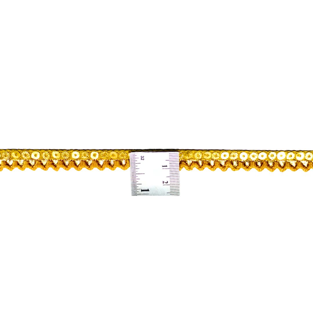 Gold decorative trim with a ruler for scale on a white background
