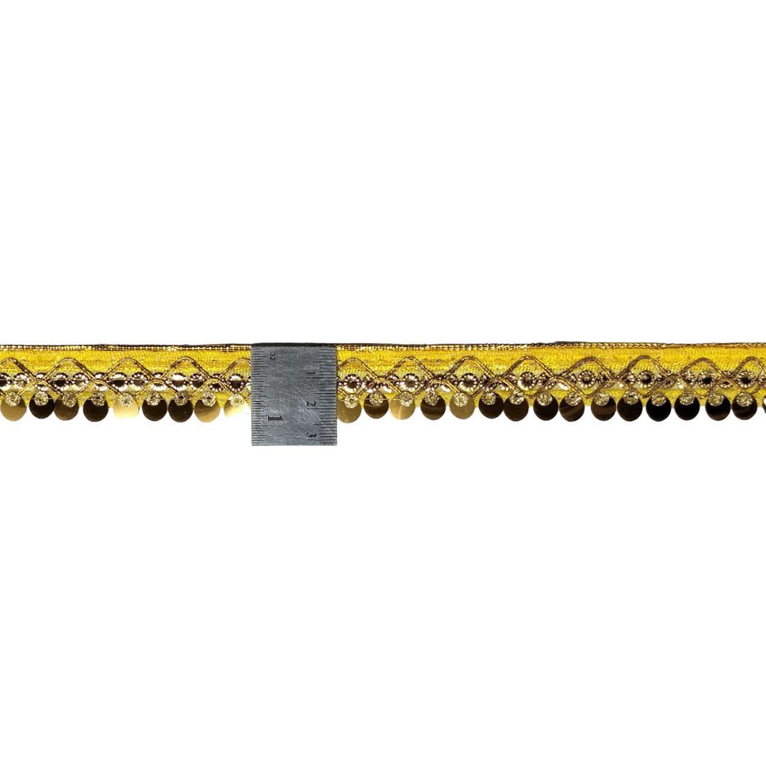 Decorative gold trim with black beads on a white background