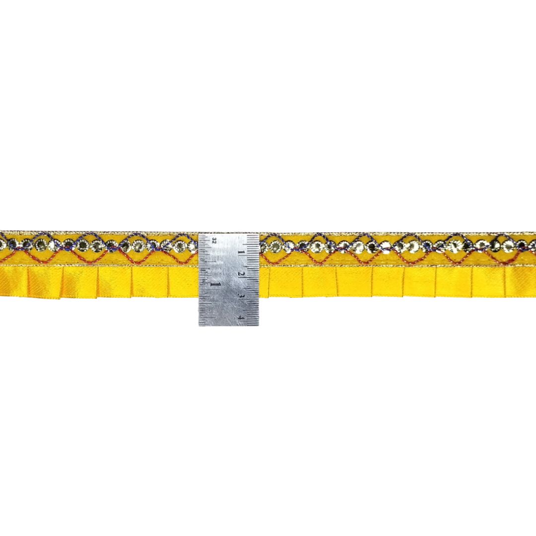 Decorative strip with yellow background and pattern, with a ruler for scale on a white background