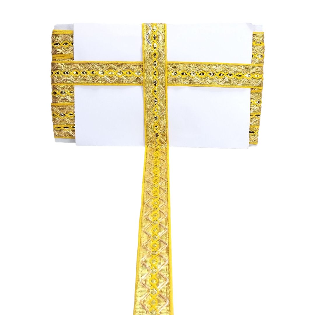Decorative gold cross with intricate patterns on a white background