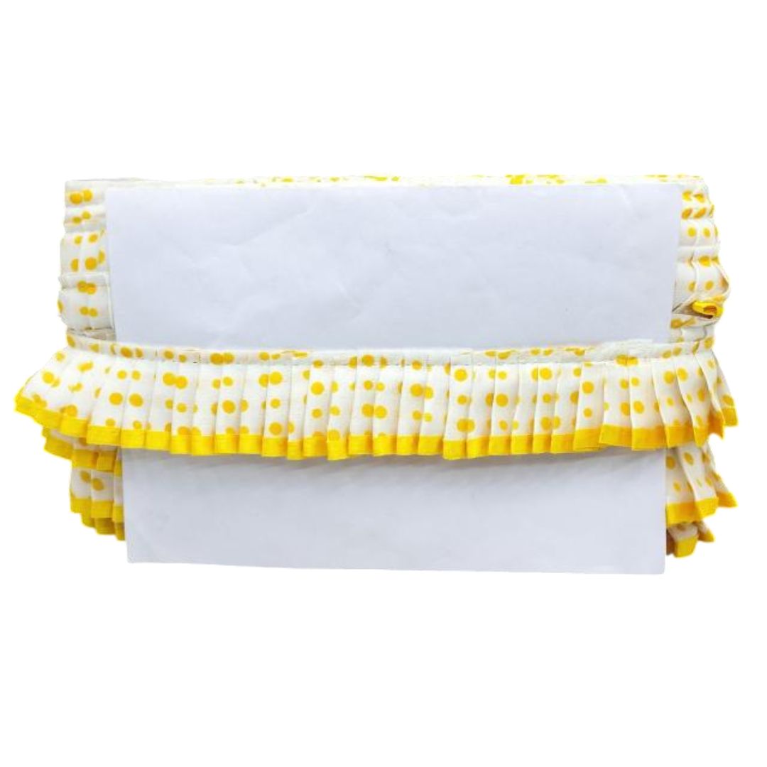 White blanket with yellow polka dot ruffles on a white background