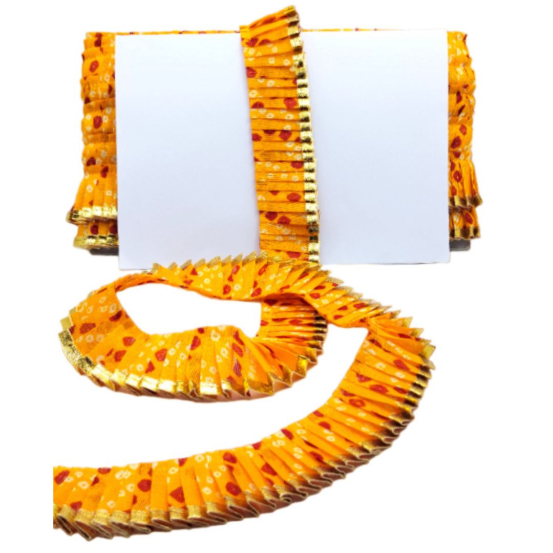 Yellow fabric with red patterns and gold trim on a white background