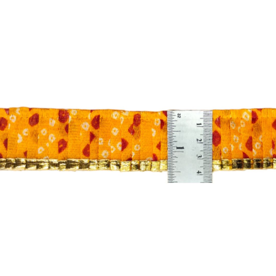 Orange fabric strip with floral pattern and a ruler for scale on a white background