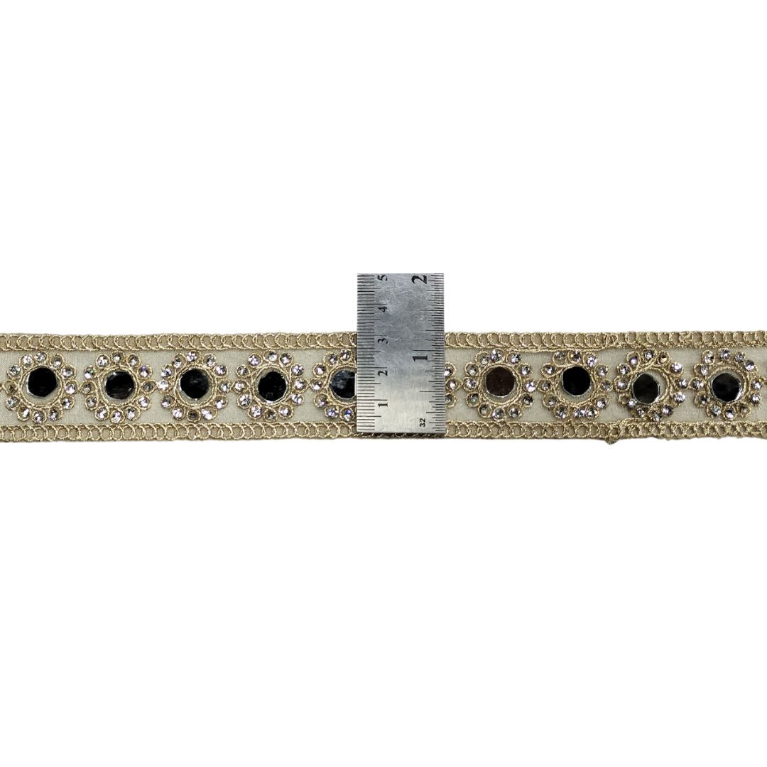 Decorative ribbon with black and clear gemstones and a ruler for scale on a white background