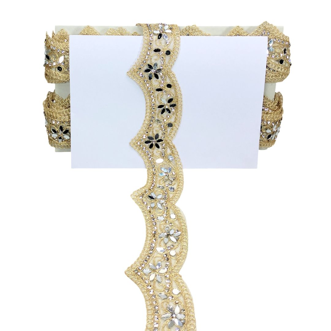 Decorative lace ribbon with gold and black floral patterns on a white background