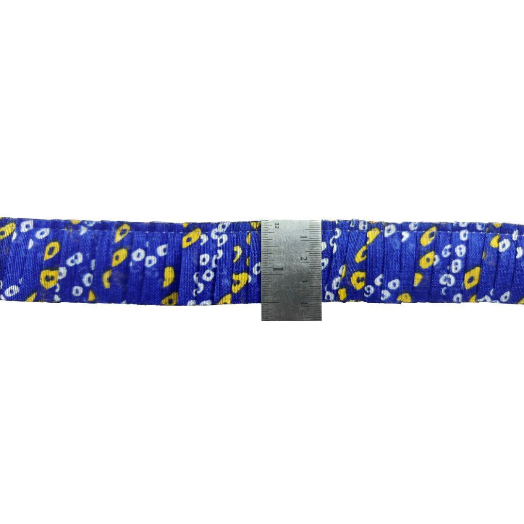 Blue belt with yellow and white pattern, measured against a ruler on a white background