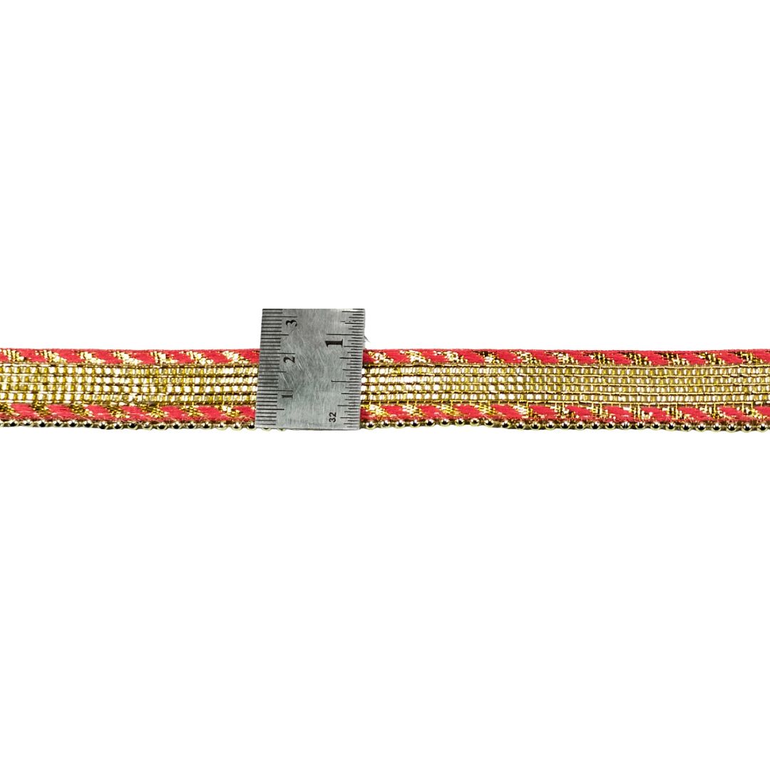 Gold and red patterned belt with a ruler for scale on a white background