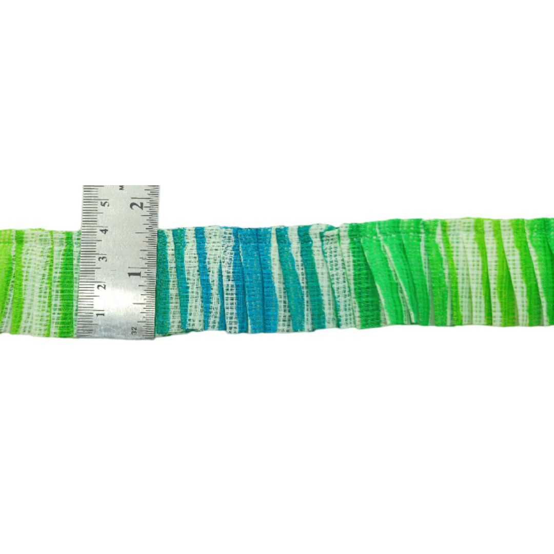 Strip of green and blue striped fabric with a ruler for scale on a white background