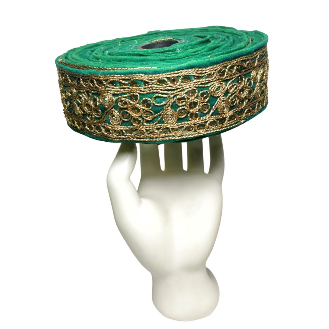 Green and gold embroidered fabric roll on a white mannequin head
