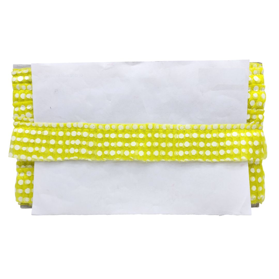 White pillow with a yellow polka dot trim on a white background
