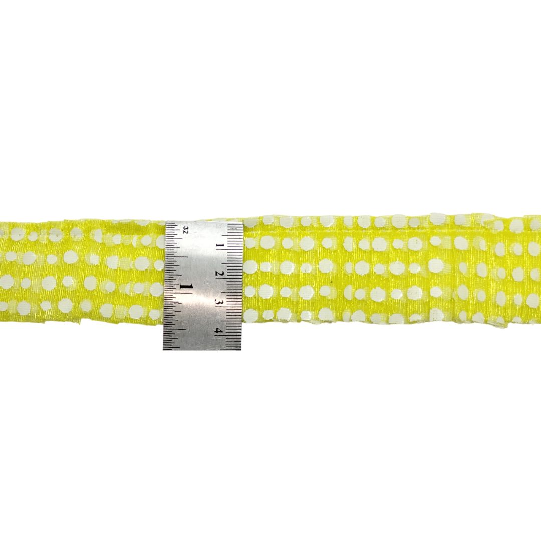 Yellow belt with white polka dots and a ruler for scale on a white background