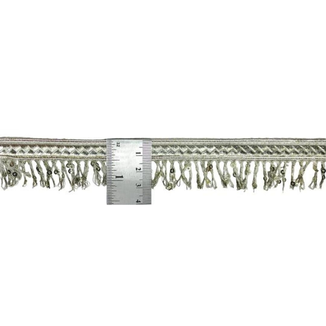 Textured fabric trim with fringe and a ruler for scale on a white background