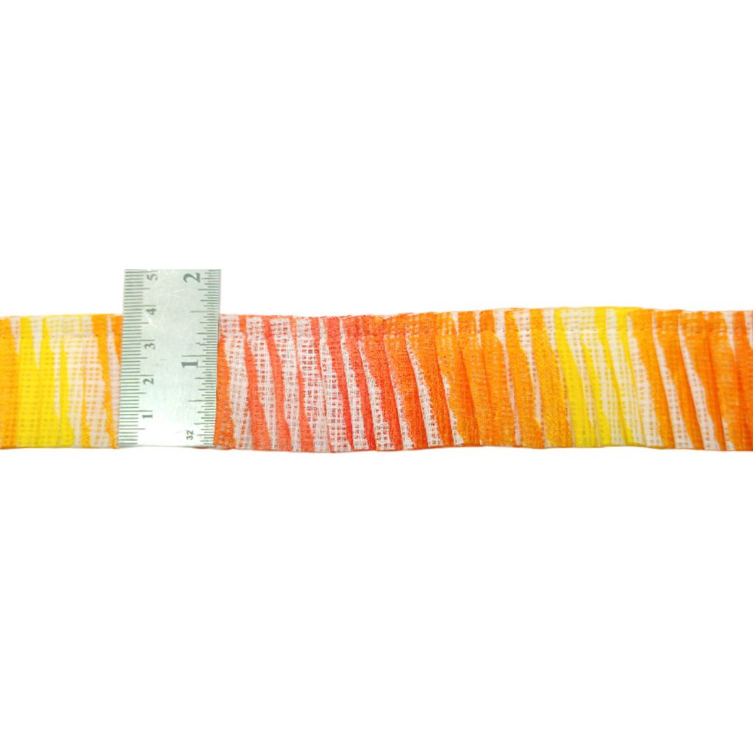 Strip of orange and yellow striped fabric with a ruler for scale on a white background