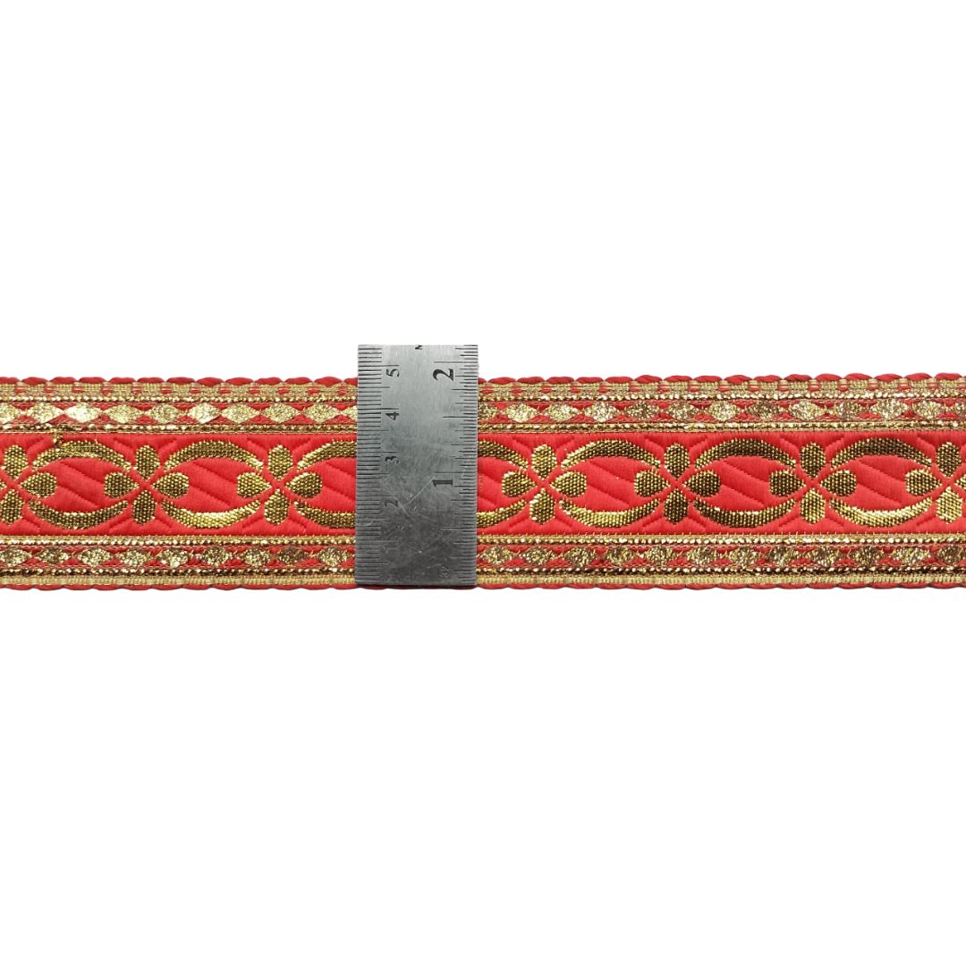 Red fabric with gold embroidery and a ruler for scale on a white background