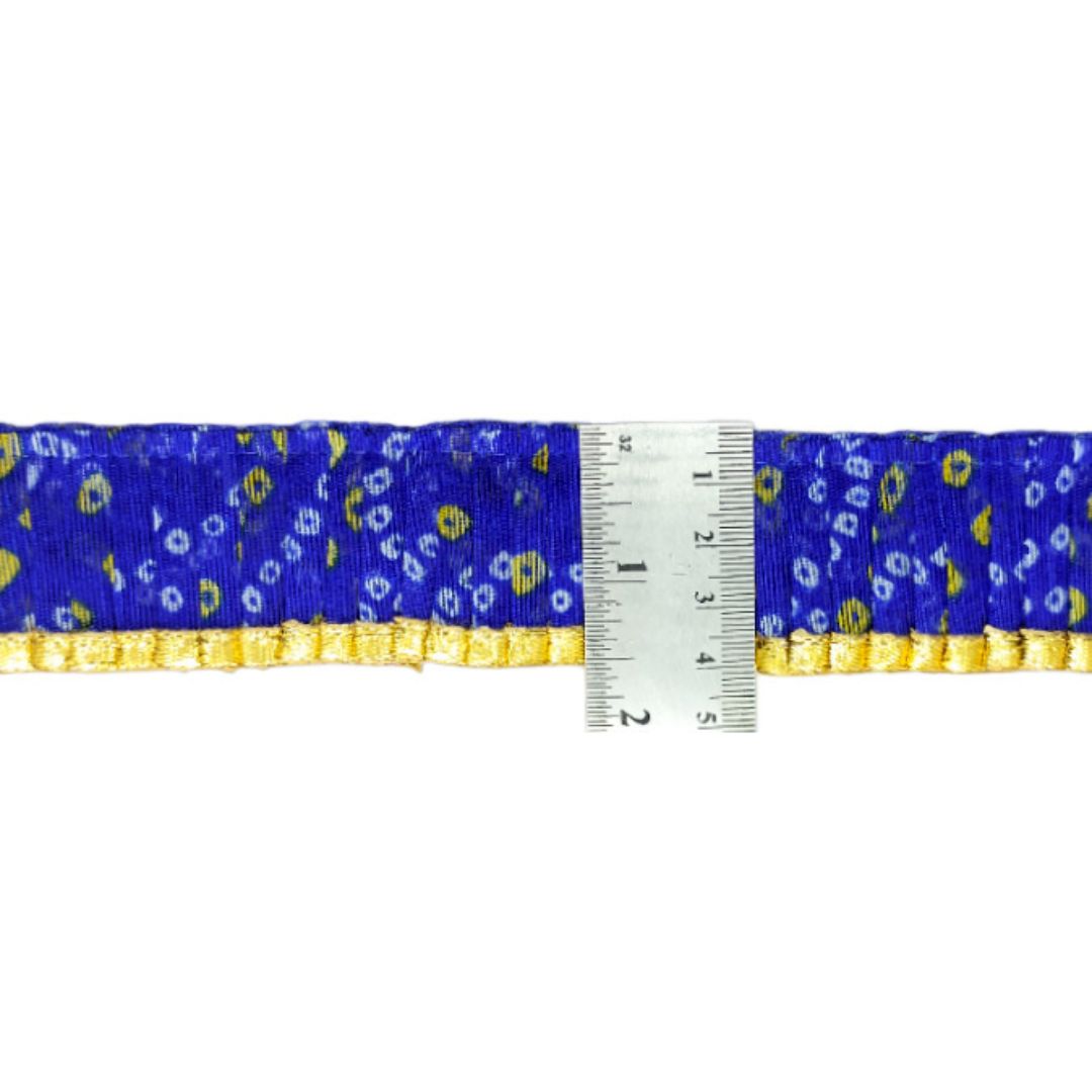 Blue ribbon with yellow floral pattern and a ruler for scale on a white background